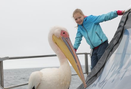 Namibia mit Kindern - Namibia individuell - Kind mit Pelikan auf Boot