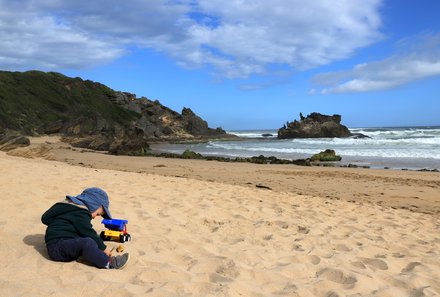 Familienreise Südafrika mit Kindern - Garden Route for family individuell deluxe - Kind sitzt im Sand