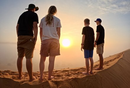 Familienreise Oman - Oman for family individuell deluxe - Familie schaut Sonnenuntergang in der Wüste