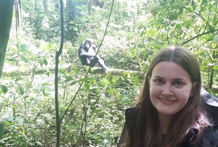 Uganda Familienurlaub - Uganda Family & Teens - Svenja und ein Schimpanse auf einem Baumstamm 