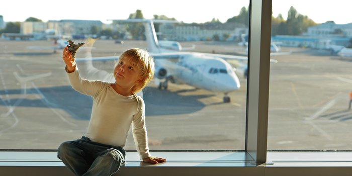 Fliegen mit Baby - Fliegen mit Baby Tipps - Kleinkind sitzt am Flughafen