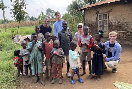 Uganda mit Kindern - Uganda Reisen mit Kindern - Reisegruppe bei Dorfbesuch