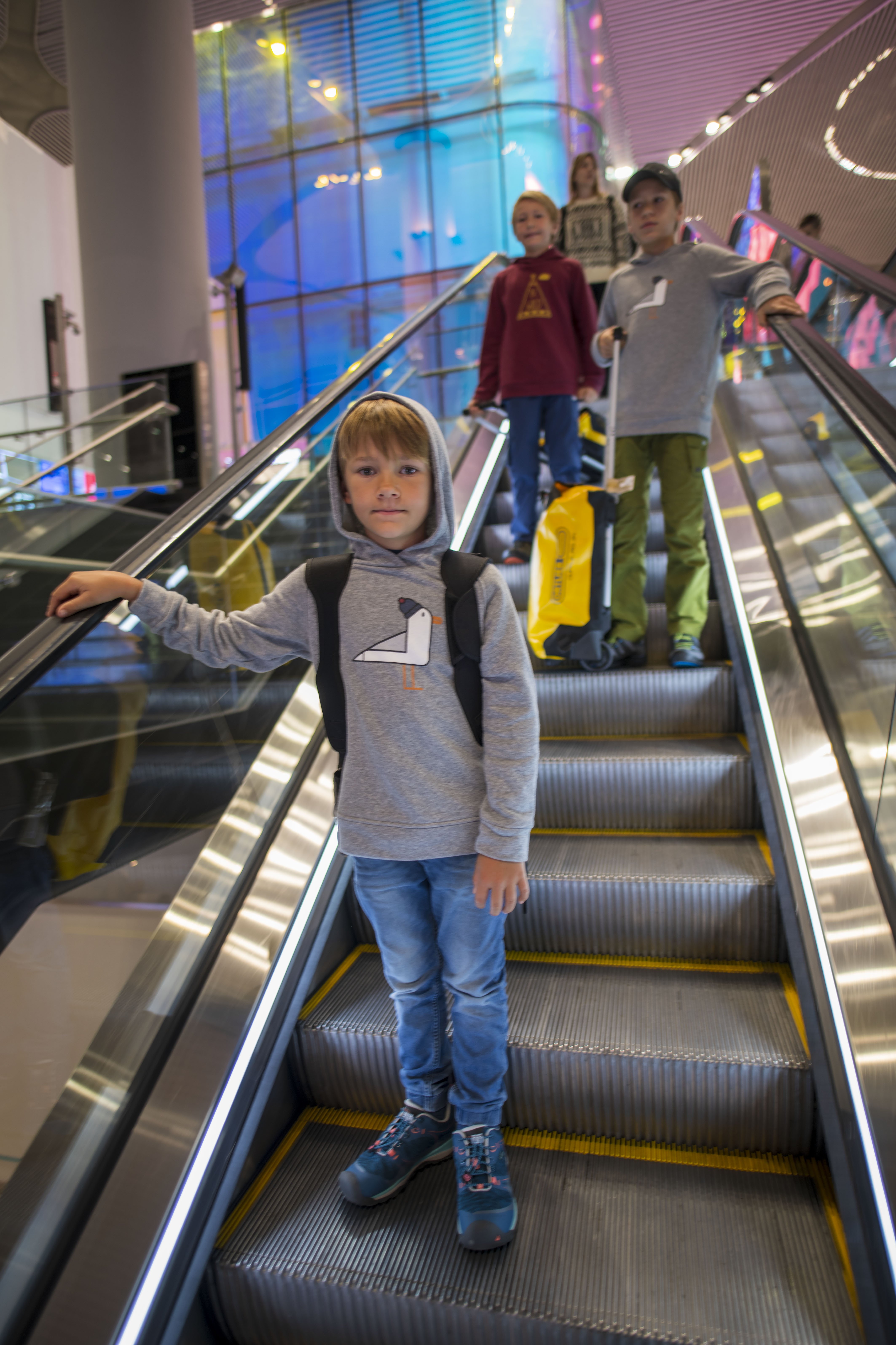 Flugreisen mit Kindern - Fliegen mit Kindern Tipps - Langstreckenflug mit Kindern - Kinder auf Rolltreppe